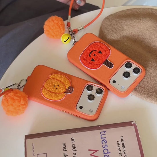 Orange Fabric Phone Case with Plush Embroidered Pumpkin & Pom-Pom Bell Wrist Strap product video v1.MP4